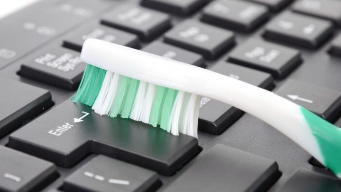 cleaning keyboard with toothbrush
